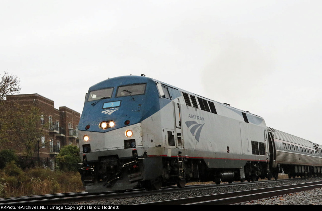 AMTK 2 leads train 80, the Carolinian, away from the station is a light rain 